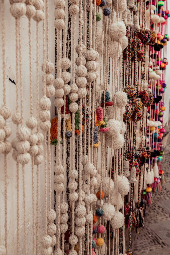 A wall of beads hanging on the side of a building.