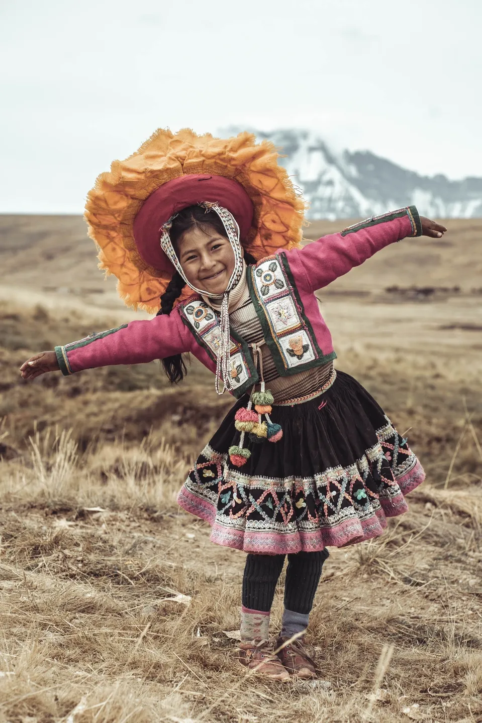 A young girl in traditional dress poses for the camera.