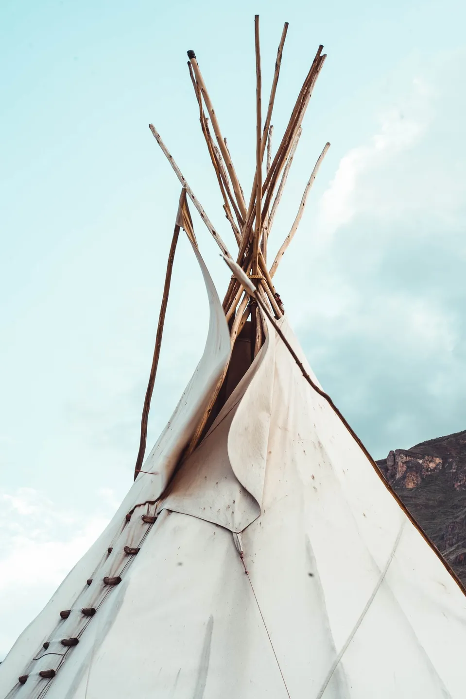 A teepee is shown with the sky in the background.