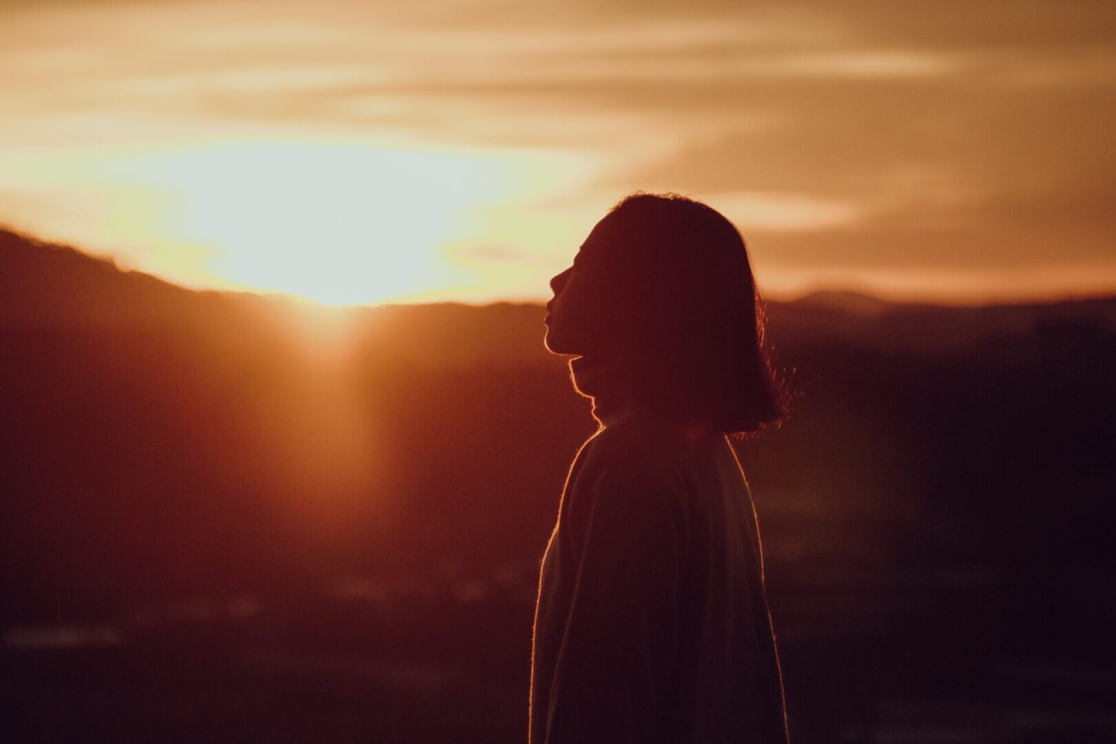 A person standing in front of the sun