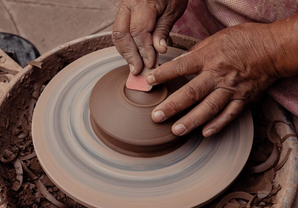 A person is making pottery on the wheel.