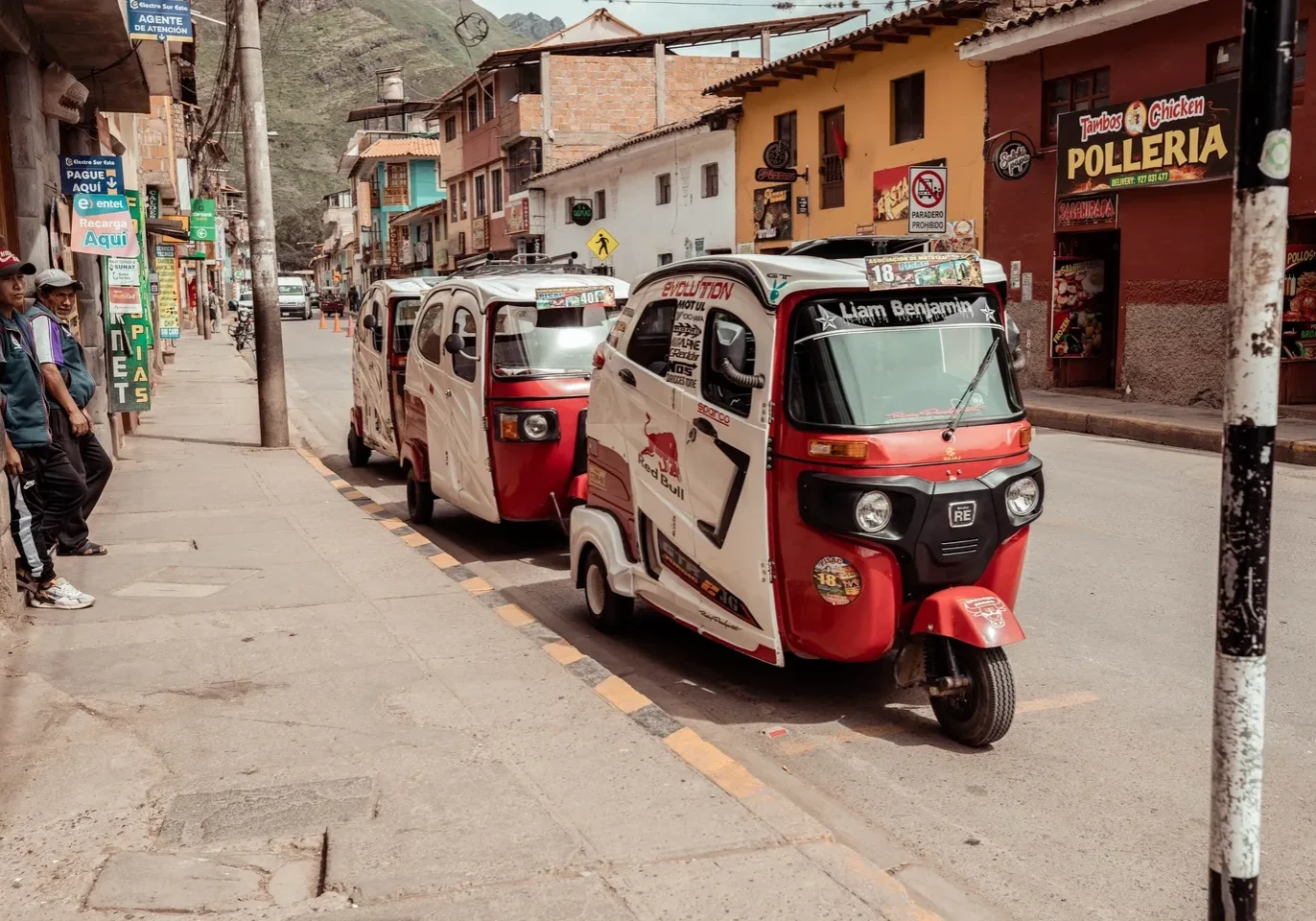 Three cars parked on the side of a street.